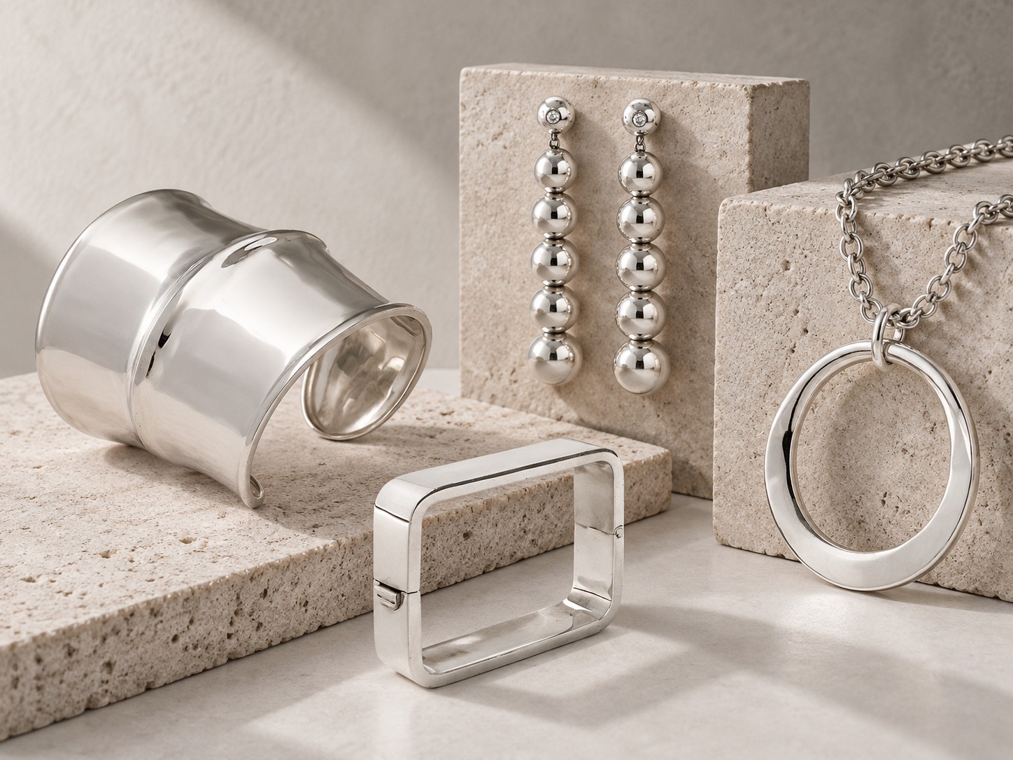 Contemporary sculptural silver jewellery by Laurent Leger, including a cuff, geometric bangle, drop earrings and pendant necklace.