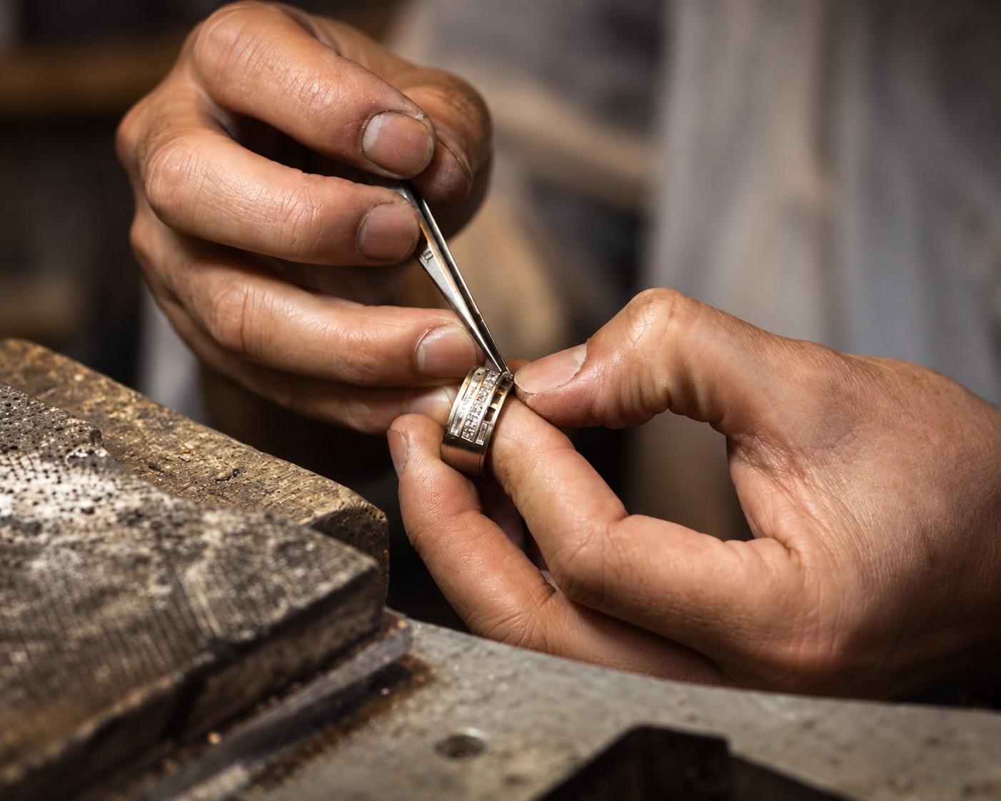 Jeweller setting stones in a silver ring at a workbench in Bali
