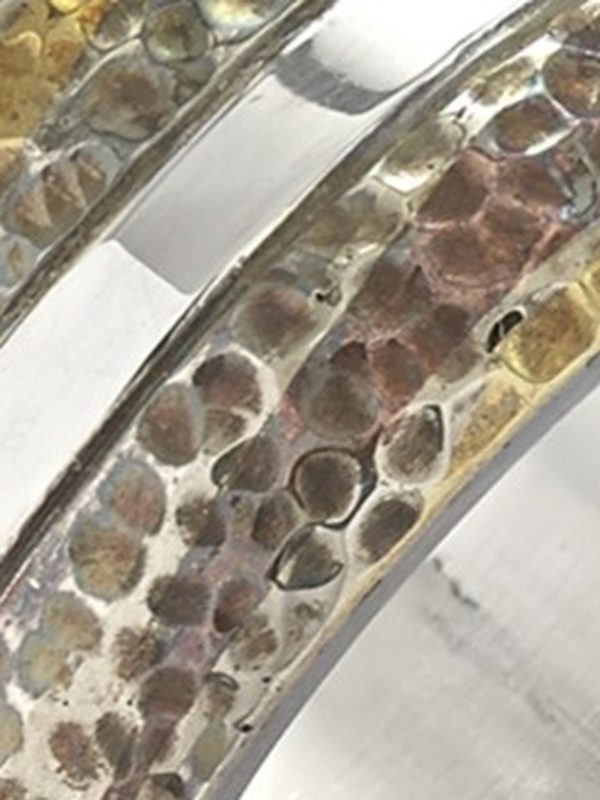Close-up of mokume gane mixed metal ring showing layered silver and copper fusion detail